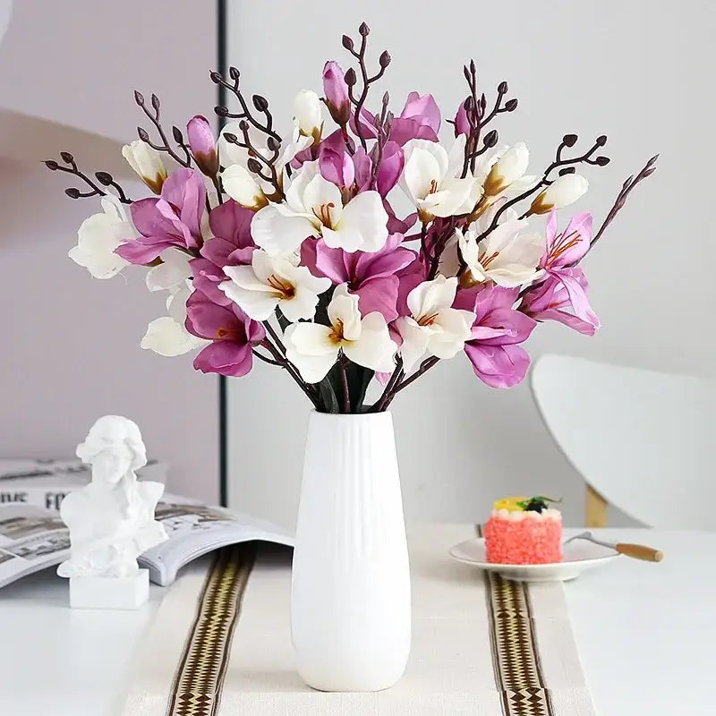A decorbites artificial orchid magnolia bouquet with purple and white flowers in a tall white ceramic vase for decor