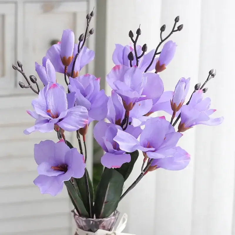 A decorbites artificial orchid magnolia bouquet of lavender petals with dark stems in a clear glass vase for home decor