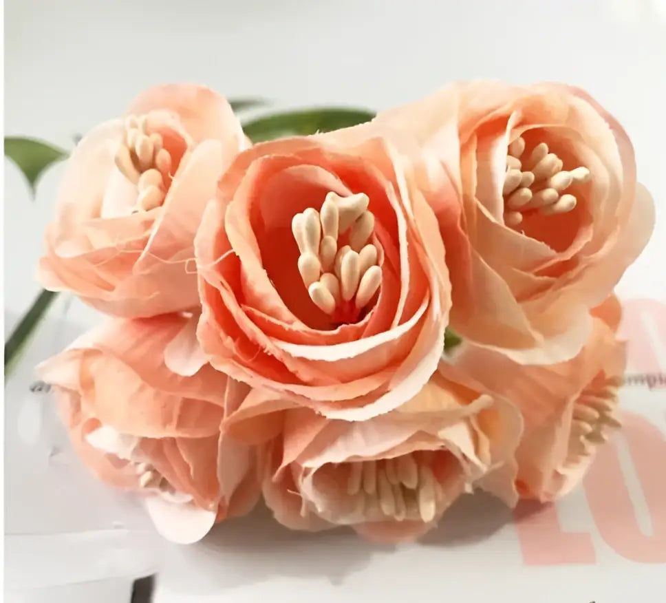 A cluster of peach-colored decorbites artificial peony tea silk flowers with delicate petals and beige stamens for decor