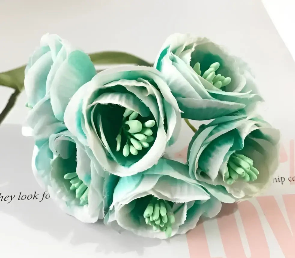 A cluster of delicate light teal and white decorbites artificial peony tea silk flowers with green centers for weddings