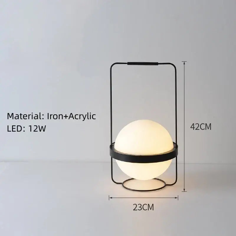 Black iron and acrylic table lamp with glowing spherical bulb complementing decorbites artificial plant pendant light