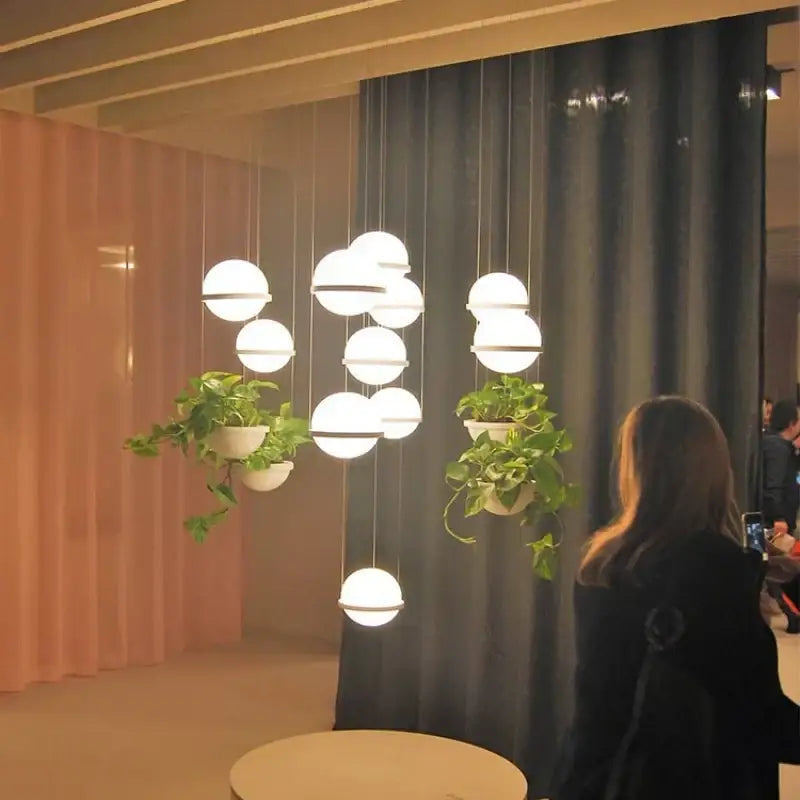 Modern spherical white glass pendant light with hanging green plants in ceramic pots decorbites artificial plant pendant