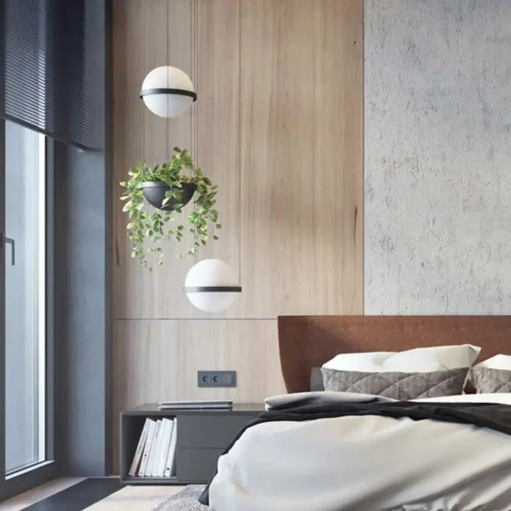 Two spherical white pendant lights with black horizontal bands featured in DecorBites artificial plant pendant light design