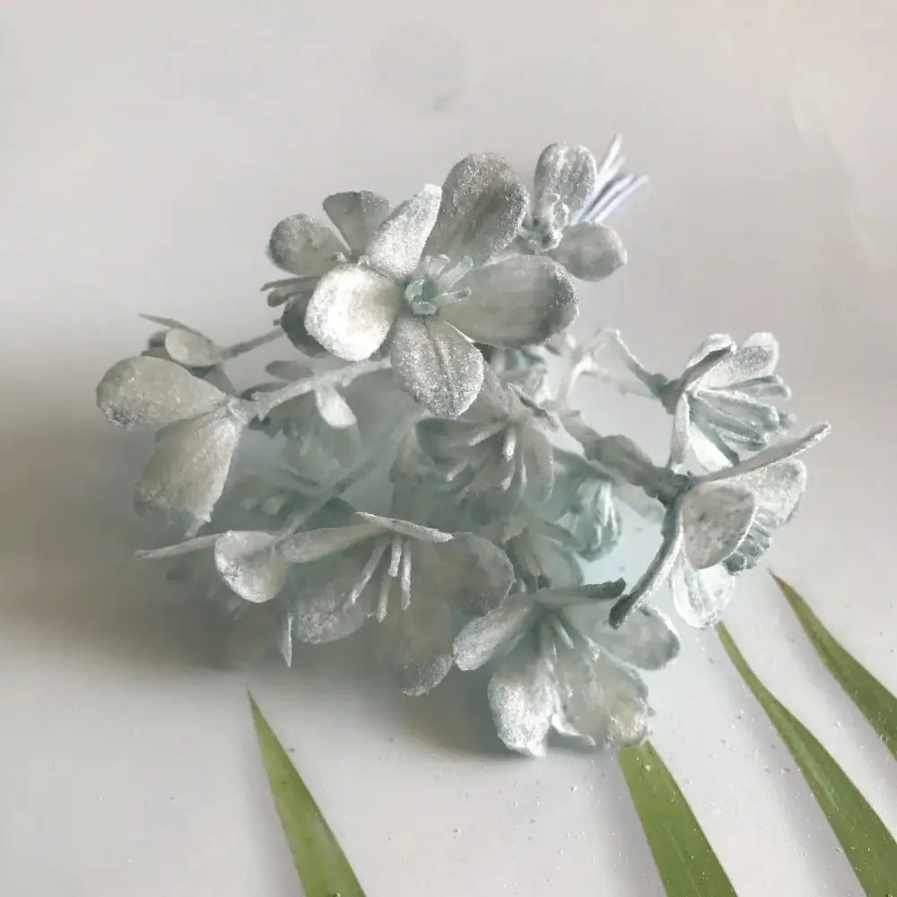 A cluster of silver-frosted artificial plants with delicate petals in decorbites artificial plants green grass decor