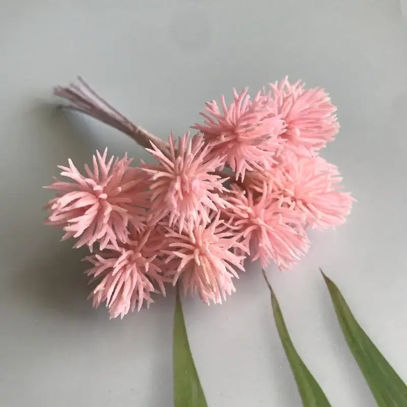 A cluster of delicate pink spiky artificial flowers with bundled stems from decorbites artificial plants set for wedding decor