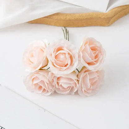 A delicate cluster of six blush pink decorbites artificial roses with soft petals in an artificial rose bouquet