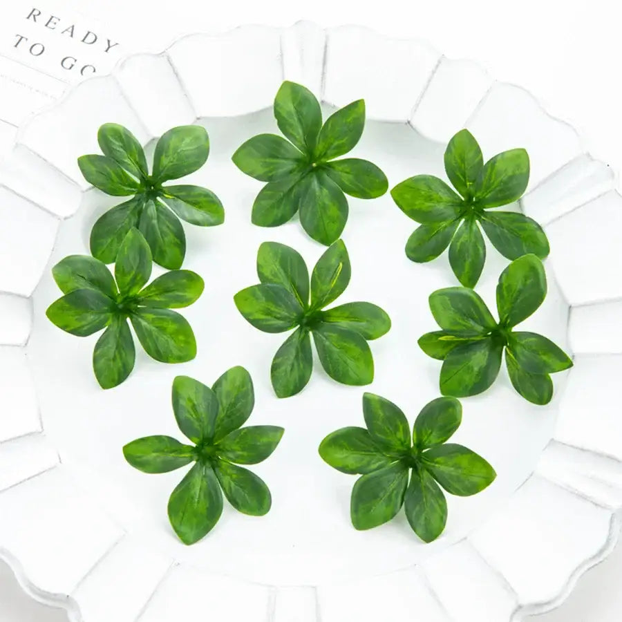 Green artificial rose leaf stems arranged on a white plate for diy wreaths and home decor by decorbites artificial rose