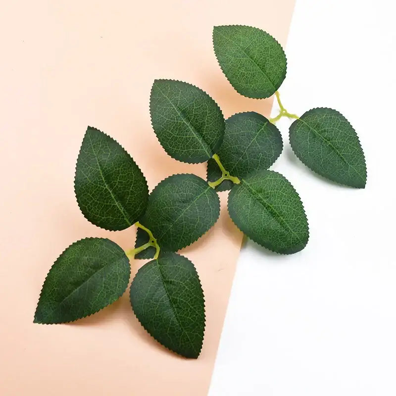 A cluster of green artificial rose leaves with detailed veins on thin stems for decorbites silk greenery wreaths