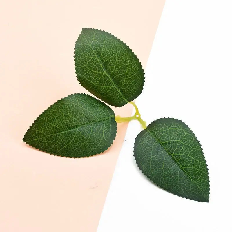 Three artificial green leaves with detailed veins and serrated edges on a light yellow stem for silk greenery wreaths