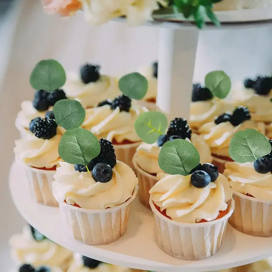 Delicate vanilla cupcakes with creamy frosting and fresh berries beside decorbites artificial roses eucalyptus home wedding christmas decor flowers