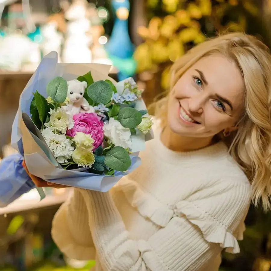 A charming bouquet of decorbites artificial roses and eucalyptus home wedding flowers in light blue wrap with plush bear