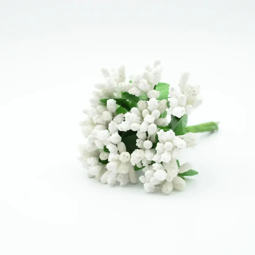 A delicate cluster of white decorbites artificial stamen flowers with green stems made from textured synthetic material