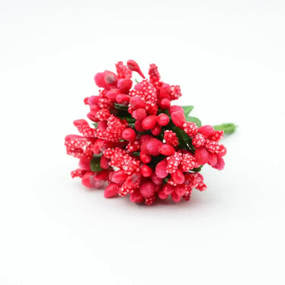 A cluster of vibrant red decorbites artificial stamen flowers with textured berries and small green leaves for home wedding decor