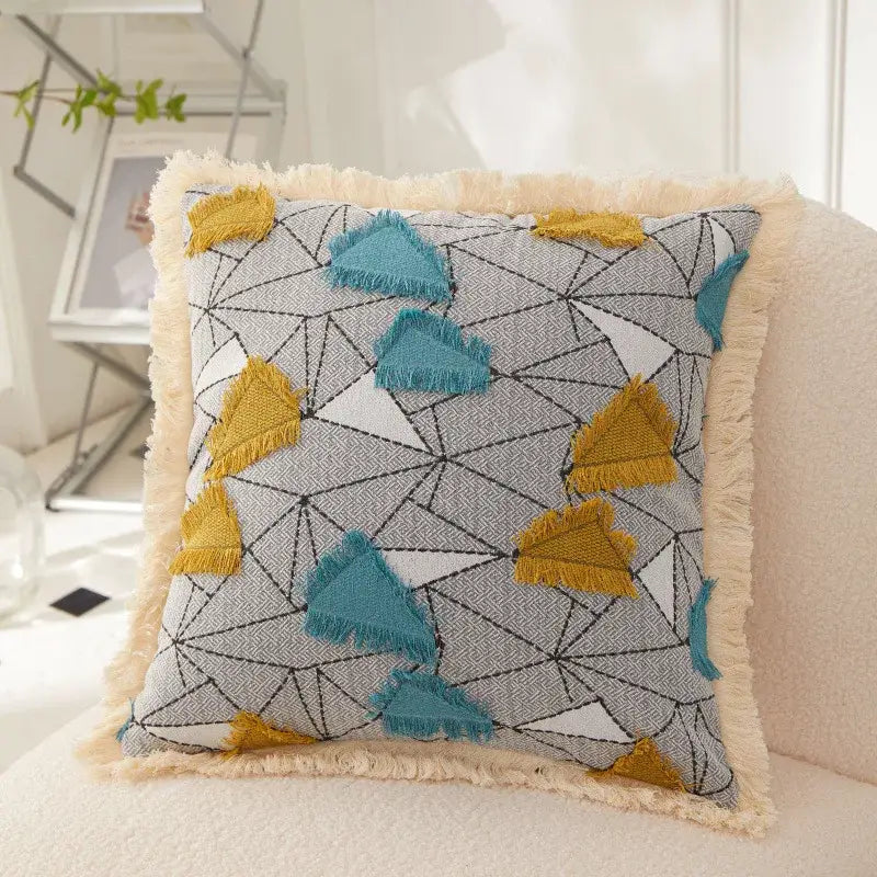 A decorbites artistic 45x45 handmade cushion cover with teal and mustard-yellow triangles on gray background and cream fringe