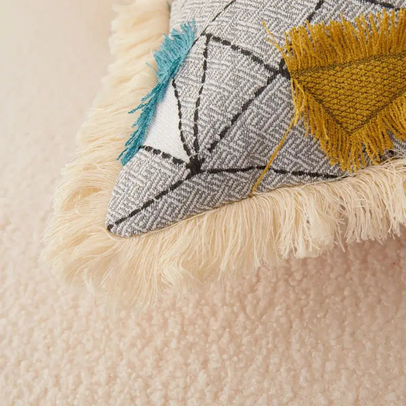 DecorBites artistic 45x45 handmade cloth cushion cover with gray and black geometric pattern, mustard patch, and teal tassel