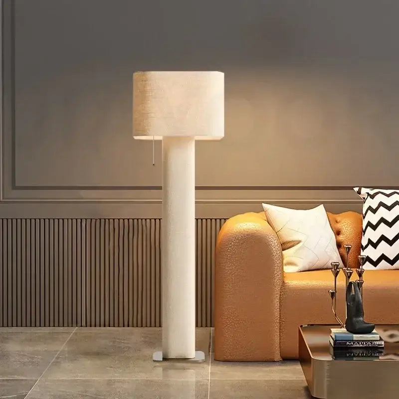 A sleek white decorbites artistic floor lamp with a cylindrical shade and minimalist design for living rooms