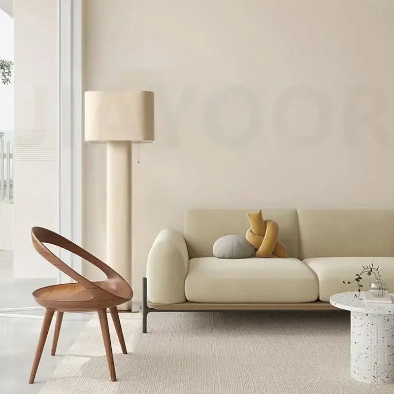 A sleek minimalist wooden chair with curved back and tapered legs beside a decorbites artistic floor lamp in wabi sabi style