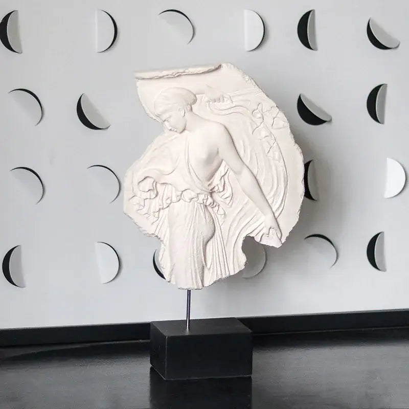 A white intricately carved decorbites artistic venus relief goddess sculpture with flowing hair and detailed fabric folds