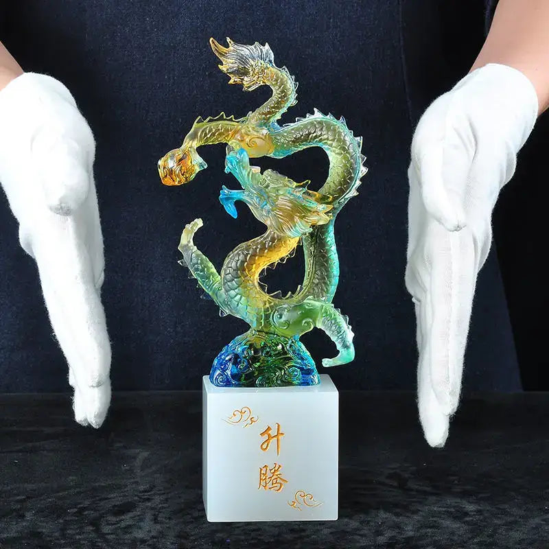 Translucent iridescent green and gold glass dragon feng shui ornament on white marble base decorbites ascending dragon