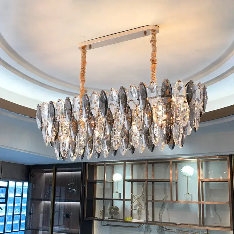 A modern decorbites ash crystal ceiling chandelier with a sleek metallic frame and clear smoky gray teardrop pendants