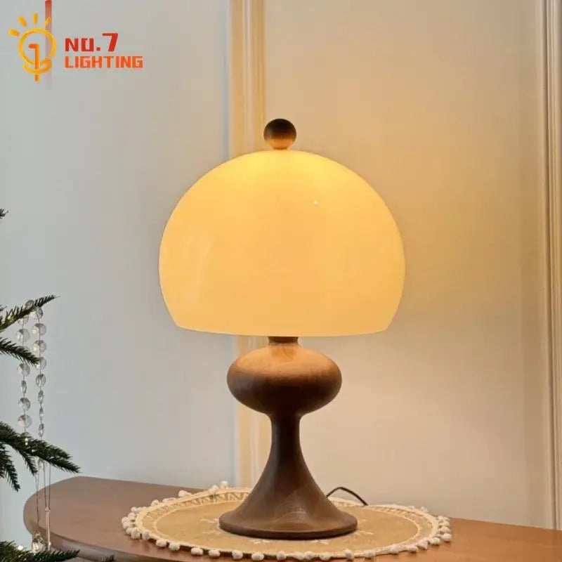 Warm yellow-glowing table lamp with dark ash wood bubble base and matte finish from decorbites ash wood collection