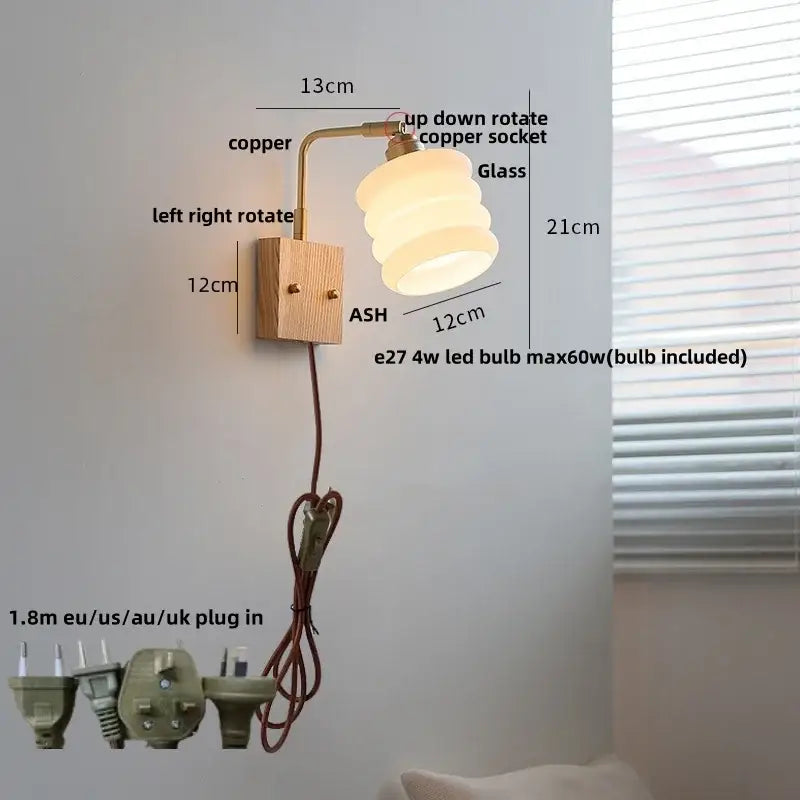A warm layered glass lampshade wall light mounted on a copper arm with an adjustable ash wood base decorbites ash wood
