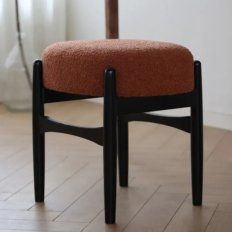 A sleek black ash wood decorbites ash wood makeup bench with a plush rust-colored upholstered seat for small spaces