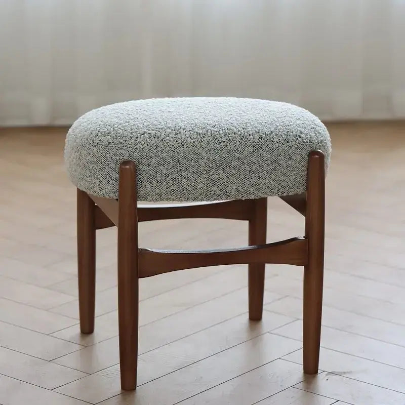 Round cushioned makeup bench with textured light gray fabric seat and sturdy ash wood legs by decorbites ash wood