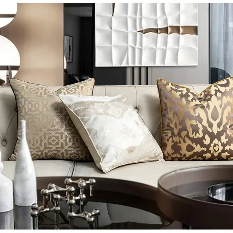 Three decorative decorbites asian landscape pillow covers in beige gold and brown jacquard fabric on tufted sofa