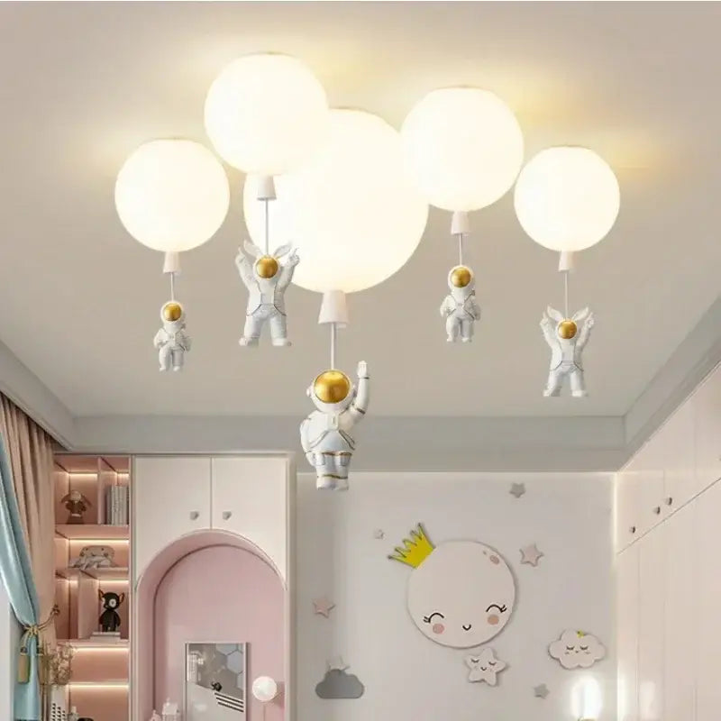 White astronaut-themed decorbites astronaut balloon ceiling light fixture with golden helmets and spherical bulbs for kids room