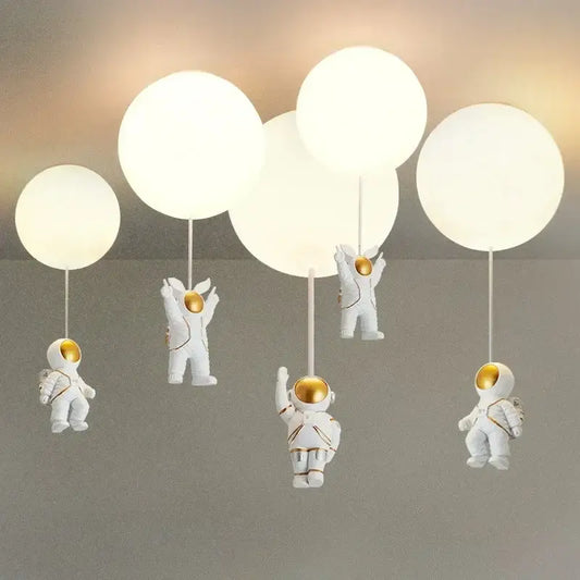 Decorbites astronaut balloon ceiling lamp featuring white astronaut figurines with gold helmets holding spherical lights
