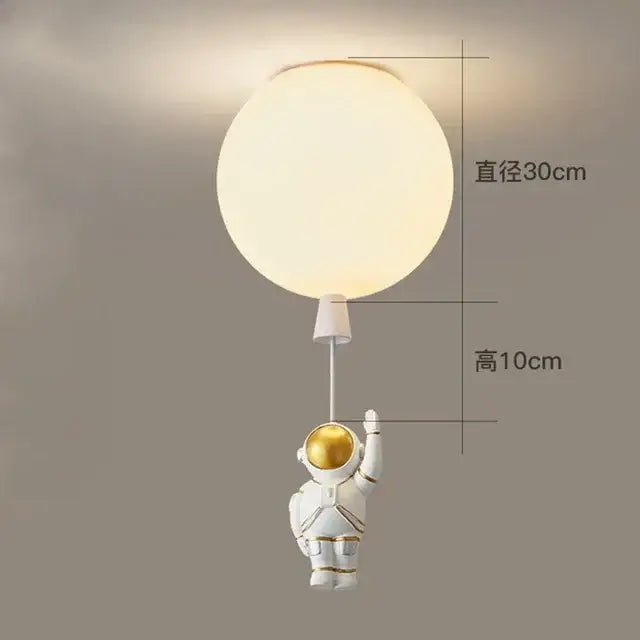 DecorBites astronaut balloon ceiling lamp features a white astronaut figurine with gold accents holding a spherical balloon lamp