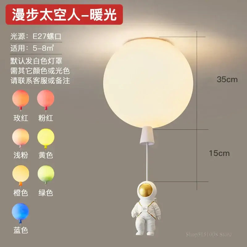 A white astronaut figurine with a gold helmet hangs from a softly glowing spherical pendant light decorbites astronaut balloon