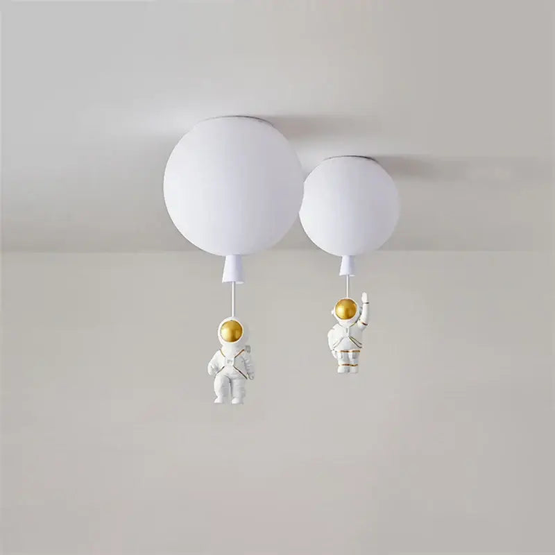 White spherical pendant light with decorbites astronaut balloon led figures featuring gold helmets for nursery room