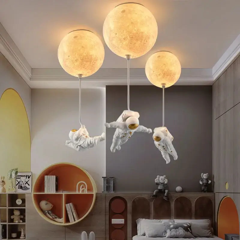 Decorbites astronaut bubble chandelier featuring three glowing moon-shaped pendant lights above floating astronaut figurines