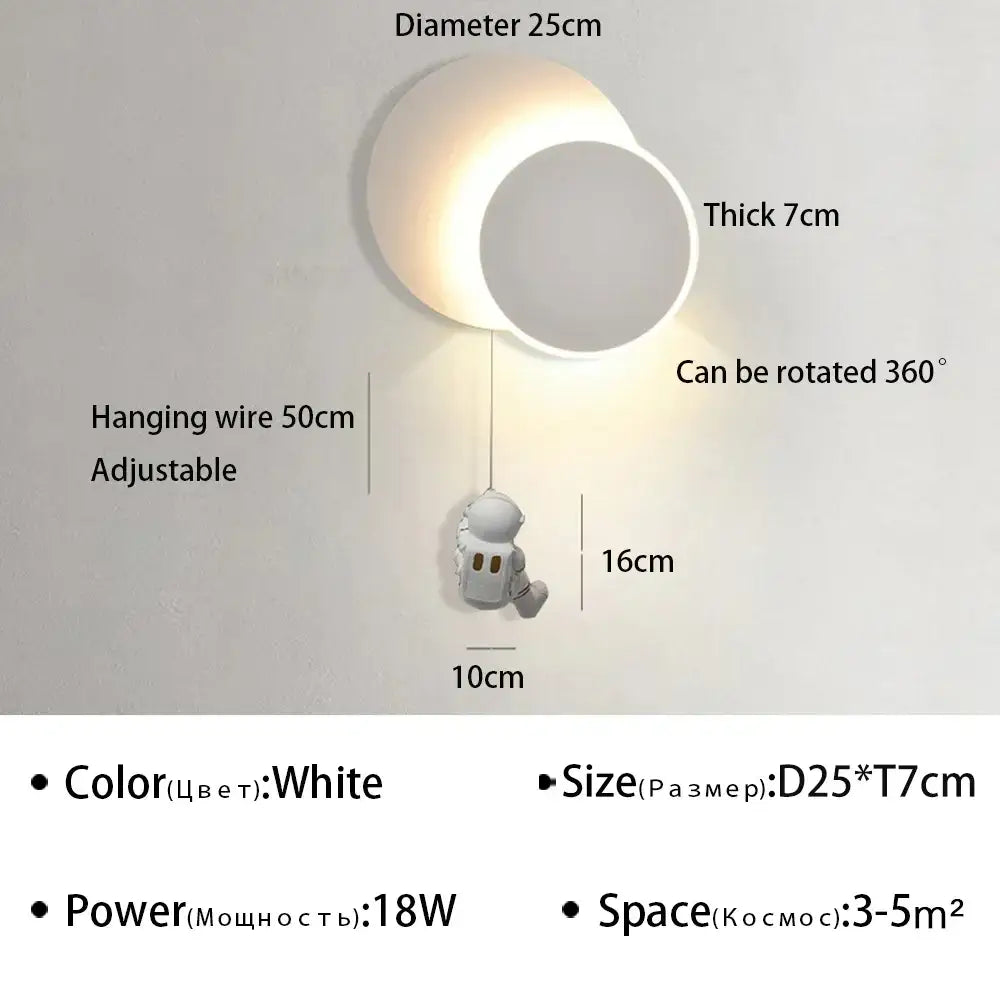 White ceramic wall lamp with moon design and astronaut cartoon figurine hanging below decorbites astronaut cartoon