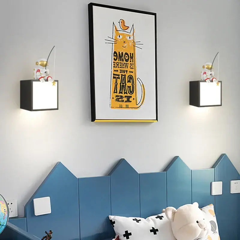 Black-framed decorbites astronaut cartoon wall art featuring a yellow cat and orange bird with home is where the cat is text