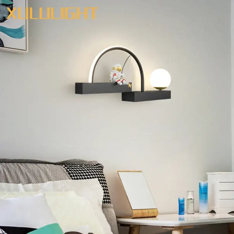 Black arched cartoon sconce metal lighting with a white globe and astronaut figurine for creative living room décor by DecorBites astronaut cartoon