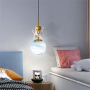 Decorbites astronaut chandelier featuring a white and gold space suit figure above a translucent globe lampshade for children’s rooms