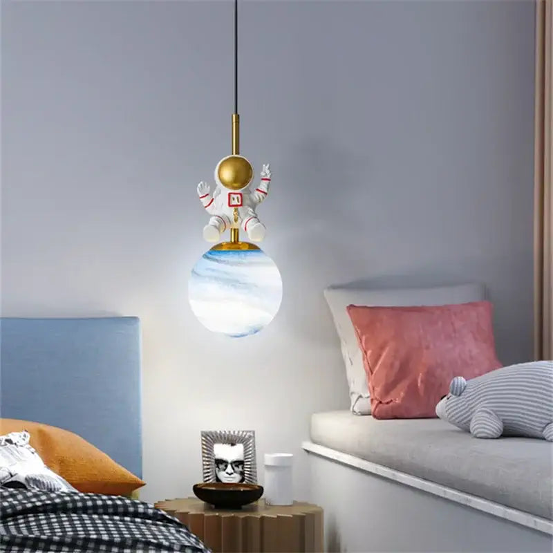 Decorbites astronaut chandelier featuring a white and gold space suit figure above a translucent globe lampshade for children’s rooms