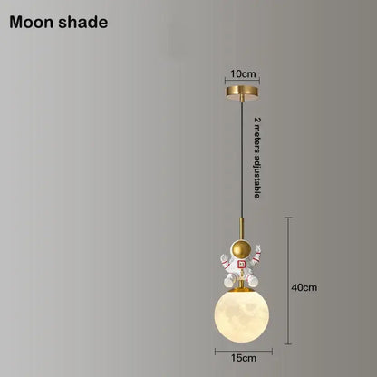 Whimsical gold-toned decorbites astronaut chandelier featuring an astronaut figurine on a glowing moon pendant light