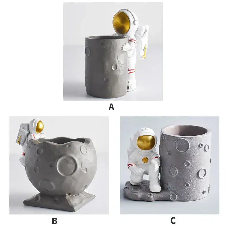 Gray DecorBites™ astronaut-themed pen holder figurines with white space suit gold visor and moon crater base for desk decoration
