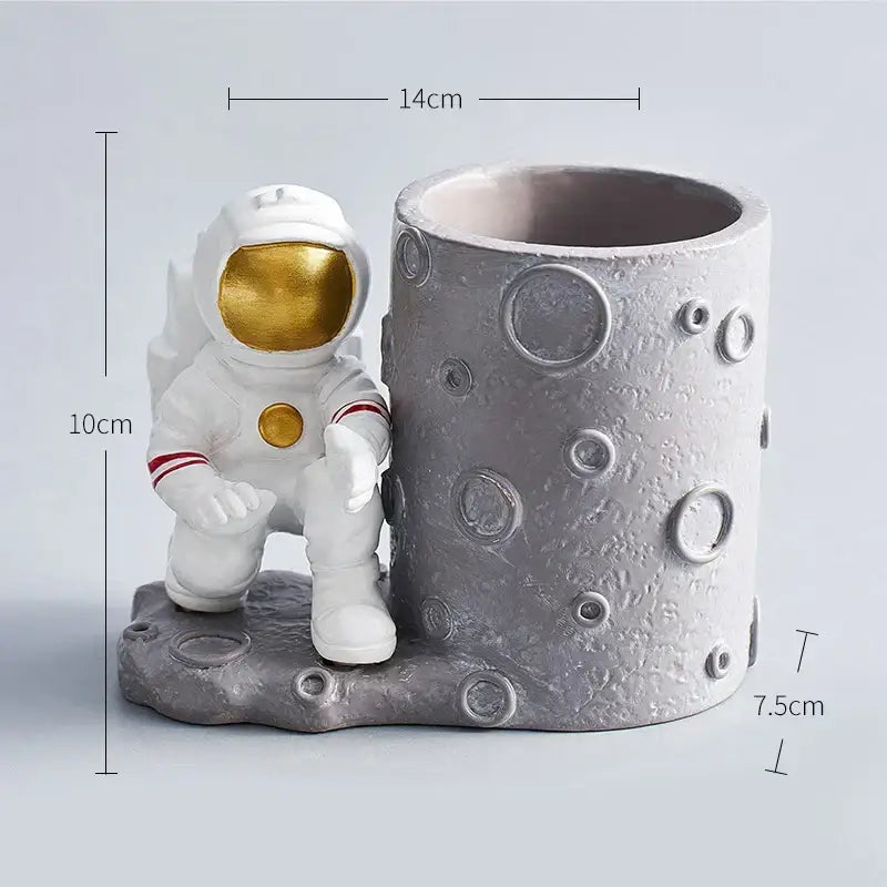 Decorbites™ astronaut cosmonaut pen holder figurines featuring white astronaut with gold accents beside textured gray moon holder