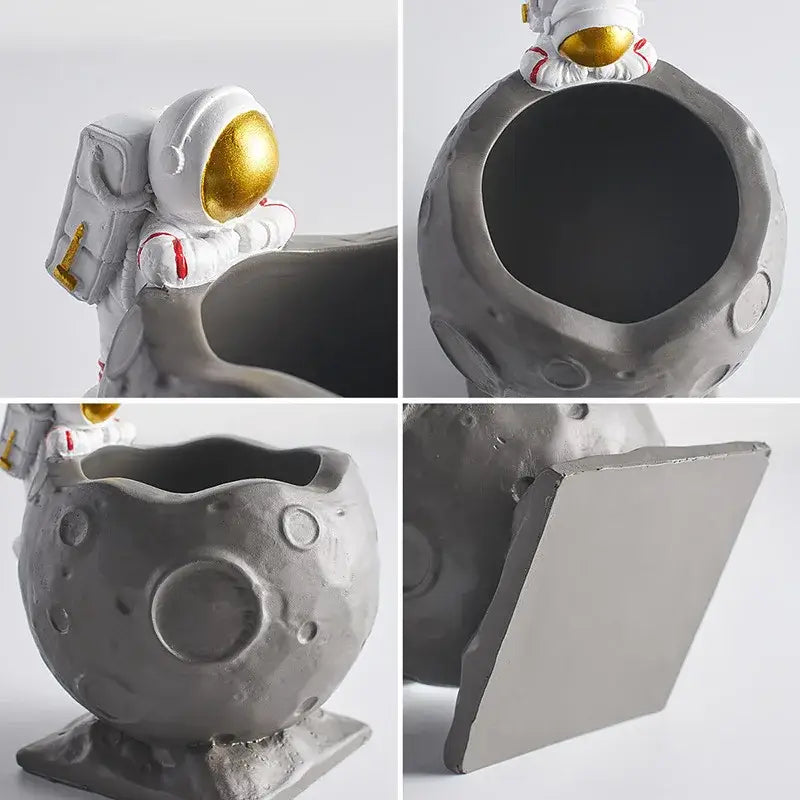 Gray moon-shaped resin pen holder figurines with white astronaut featuring gold visor and red accents for desk decor
