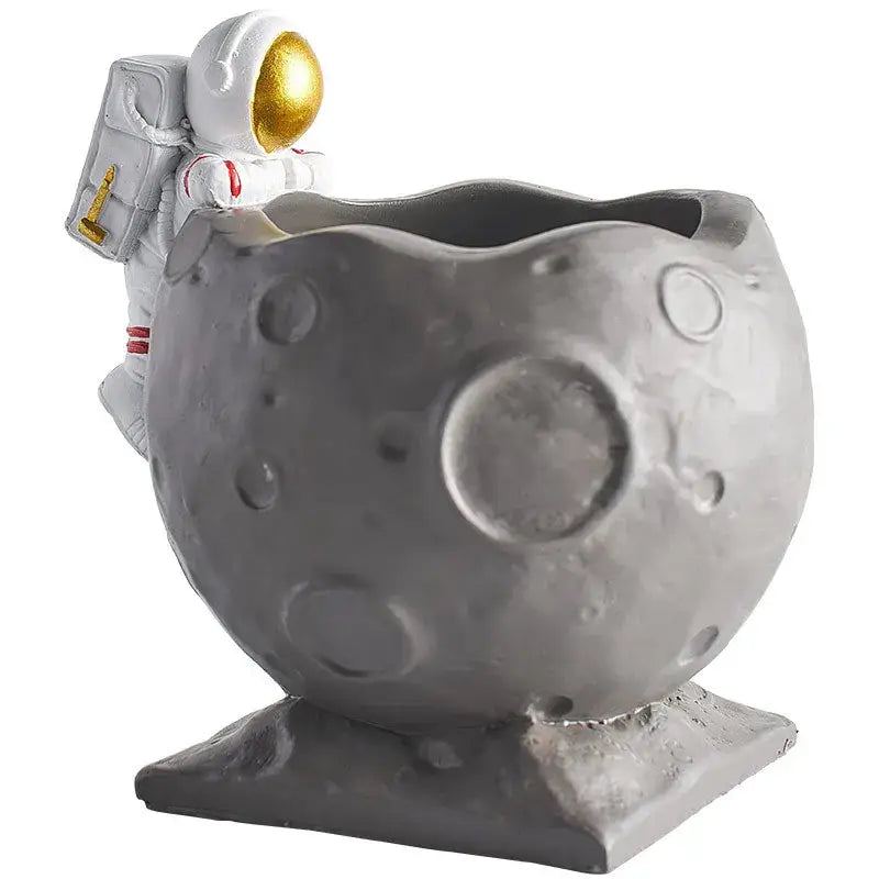 Gray moon-shaped planter with white astronaut figurine featuring gold accents decorbites™ pen holder figurines