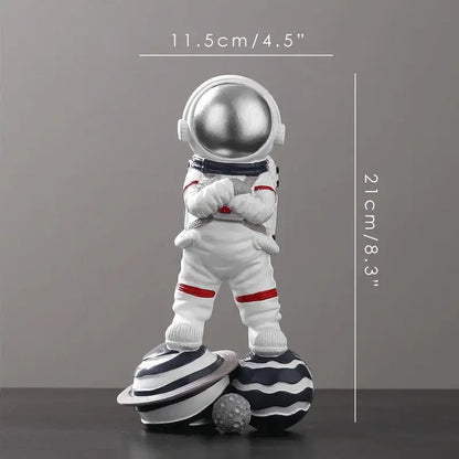 White decorbites astronaut figurine abstract sculpture with silver helmet and red accents on stylized planets for decor