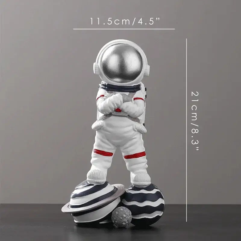 White decorbites astronaut figurine abstract sculpture with silver helmet and red accents on stylized planets for decor