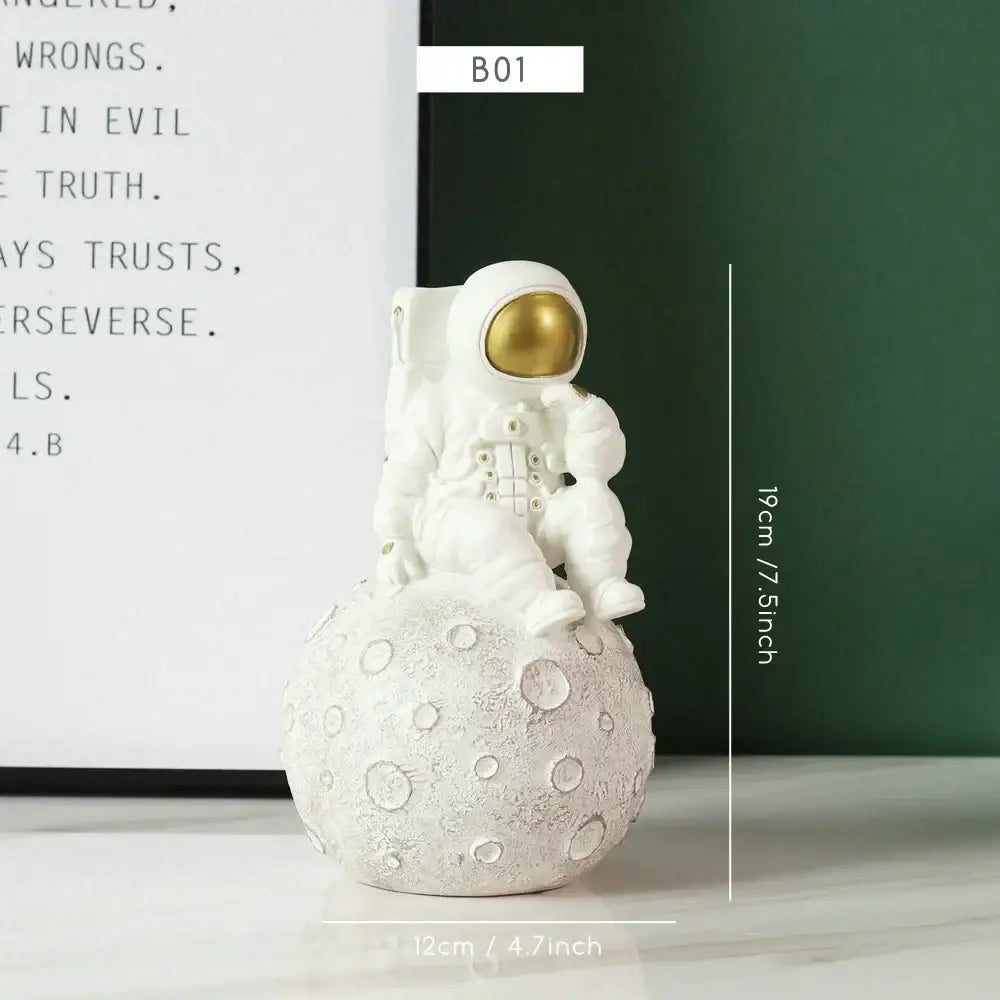 Decorbites astronaut figurine abstract sculpture in white with gold visor seated on textured moon surface for modern decor