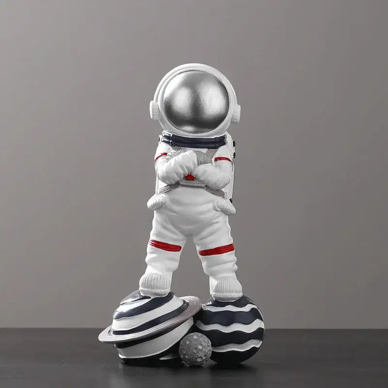 Decorbites astronaut figurine abstract sculpture featuring a white figurine with silver helmet and red accents on planets