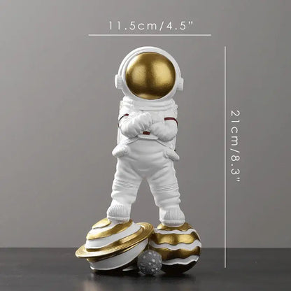 Decorbites astronaut figurine abstract sculpture in white with a gold helmet standing on two golden striped planets for modern decor